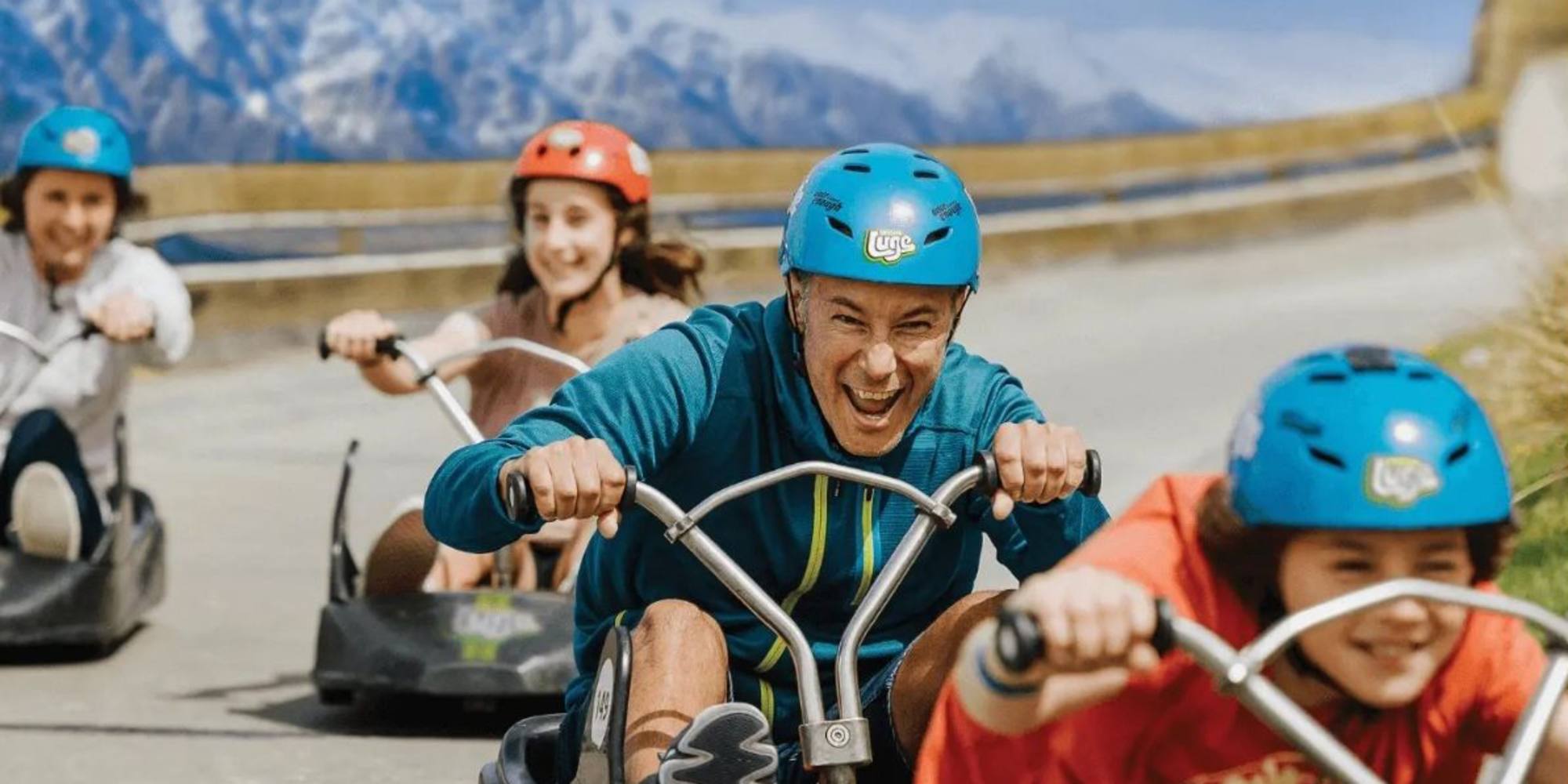 A family enjoying luging at Queenstown's Skyline Ben Lomond trail near Queenstown